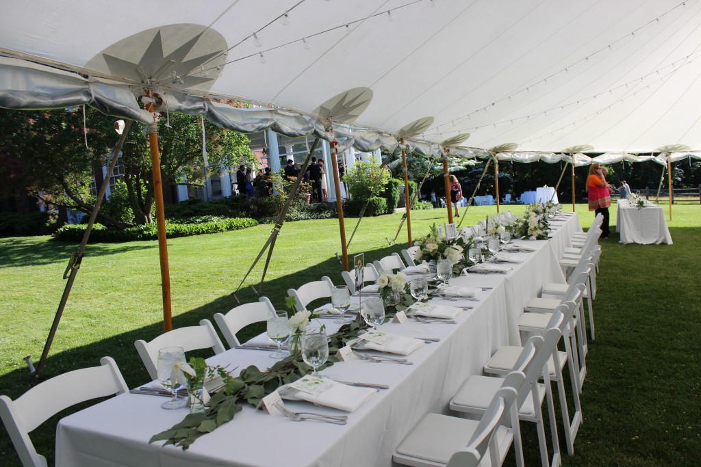 Elegant greenery decorates the tables under tent.