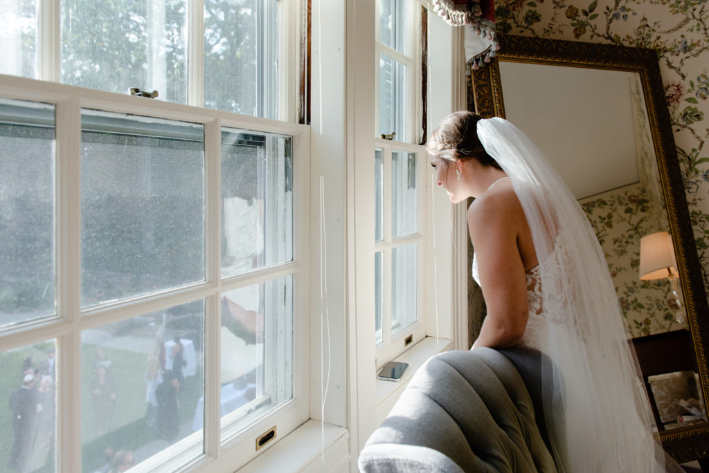 Bride views guests from window